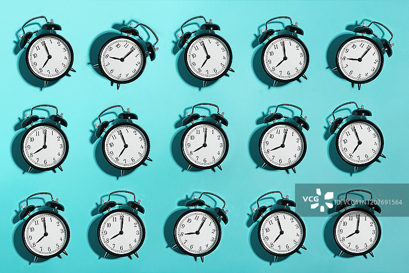 蓝色背景上的黑色闹钟图片素材