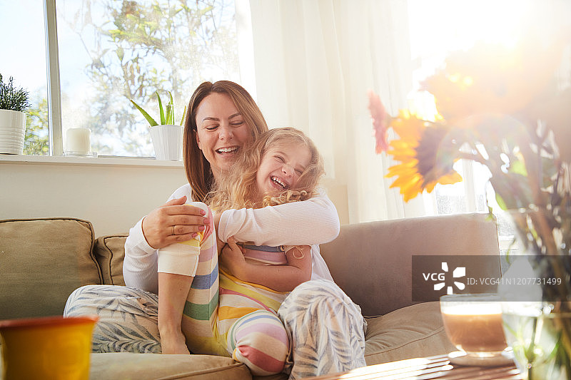 早上在家拥抱小女儿大笑的妈妈图片素材