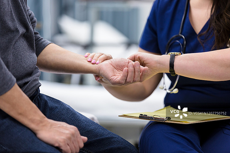 女护士为老年男子测量脉搏图片素材