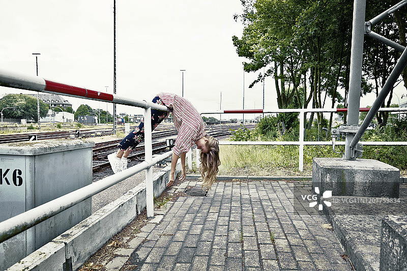 年轻女性倚靠在栅栏上图片素材