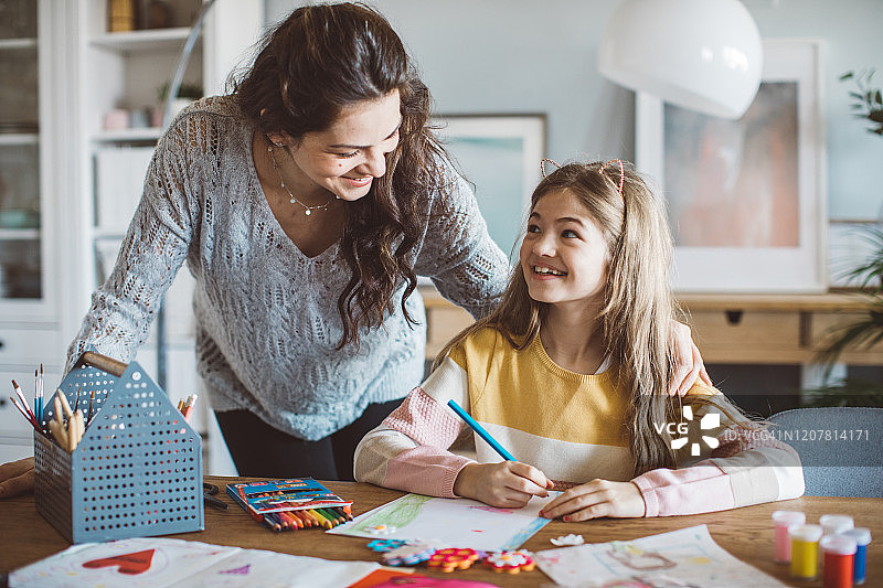 母亲帮助女儿做家庭作业图片素材