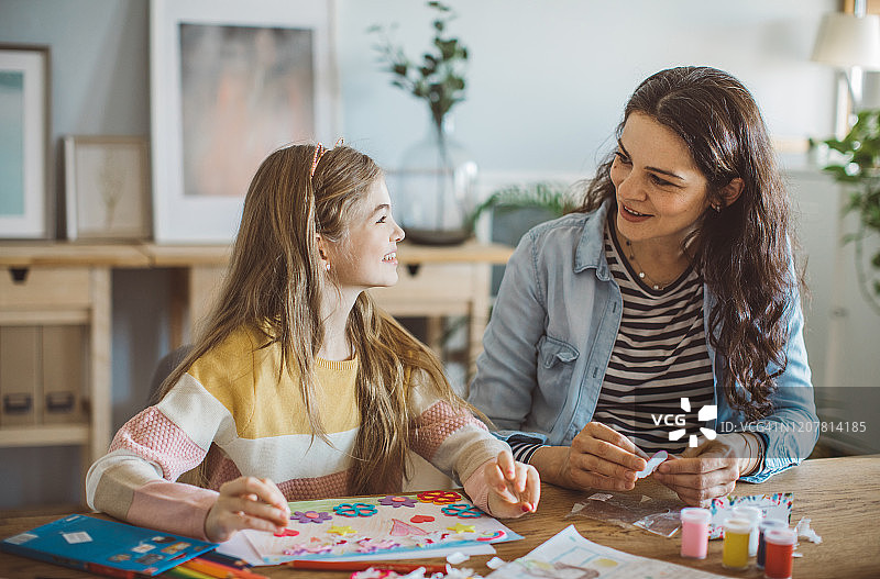 母亲帮助女儿做家庭作业图片素材