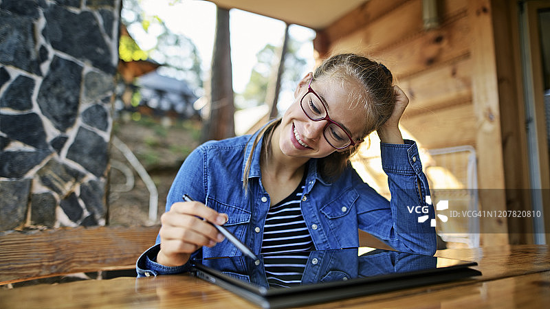 在现代笔记本电脑上享受绘画乐趣的少女图片素材