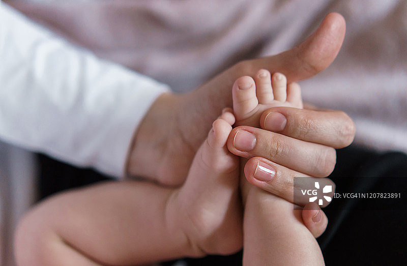女人手捧新生婴儿的小脚图片素材