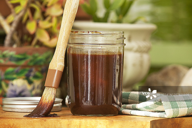 户外，打开的罐子里的自制烧烤酱和刷子图片素材