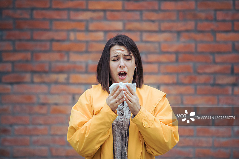 生病的年轻女子擤着鼻涕图片素材