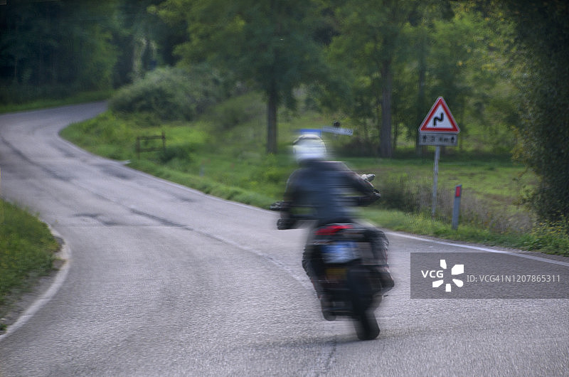 在开放道路上骑摩托车的男人图片素材