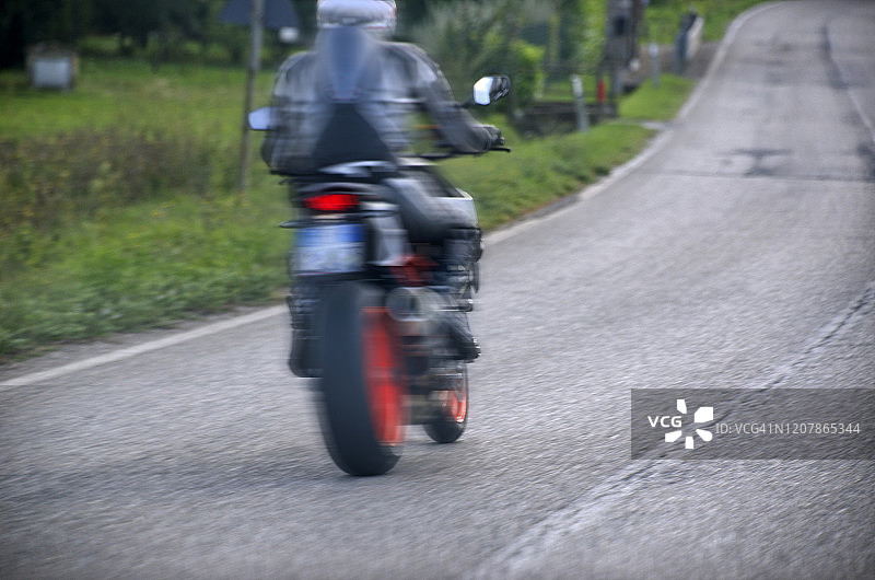 在开放道路上骑摩托车的男人图片素材