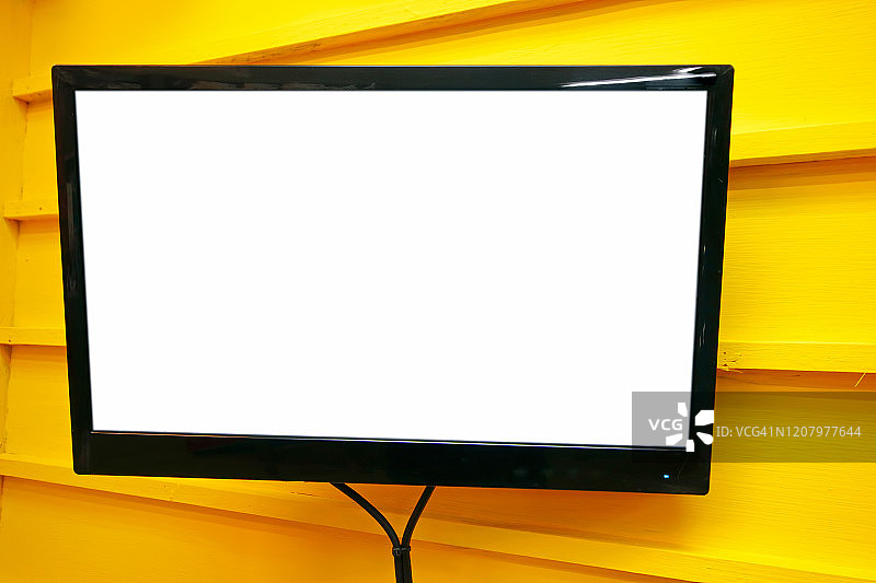 黄色墙壁上的LED电视空白白色屏幕图片素材