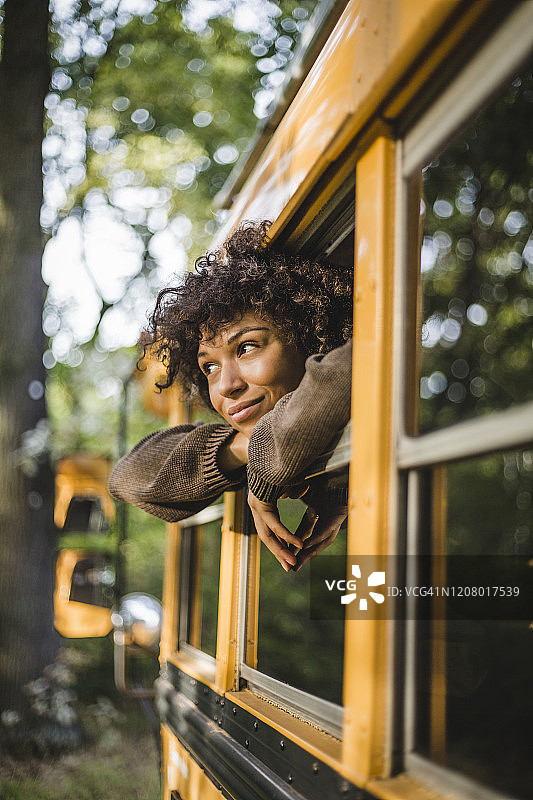 露营时，若有所思的年轻女子看着房车窗外图片素材