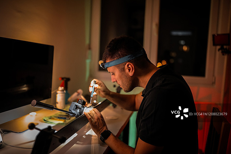 正在修理相机滑轨的年轻男人图片素材