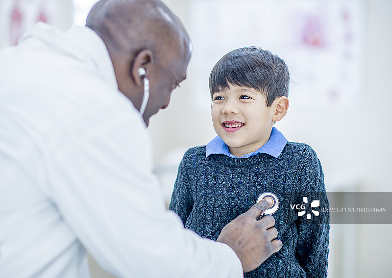 男人医生正在听小男孩的心跳照片图片素材