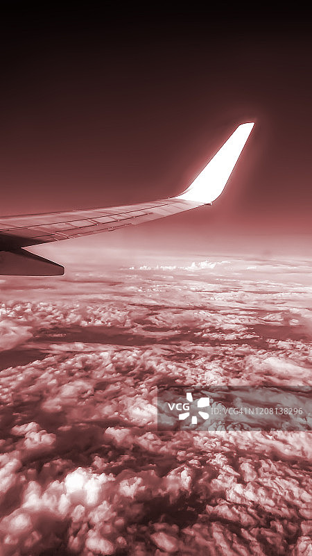 飞机舷窗外的鸟瞰图，飞机机翼和云彩图片素材