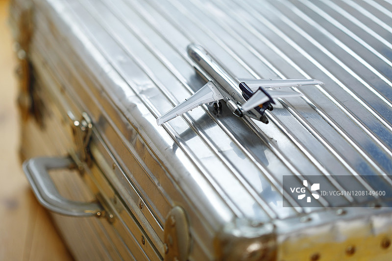 光亮模型飞机和铝制手提箱图片素材