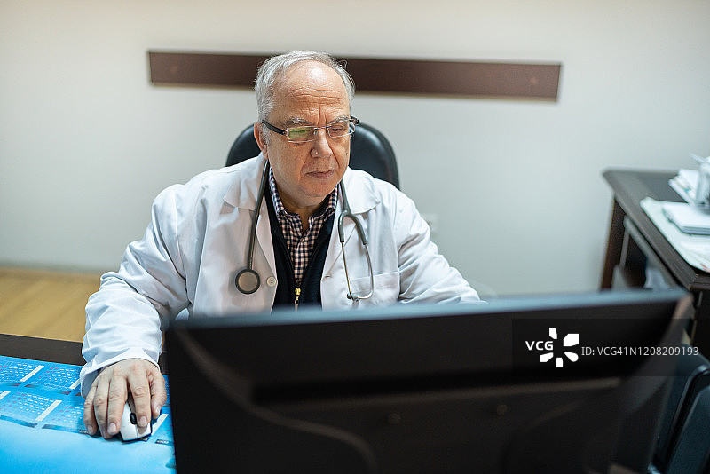 年长的医生正在使用电脑图片素材