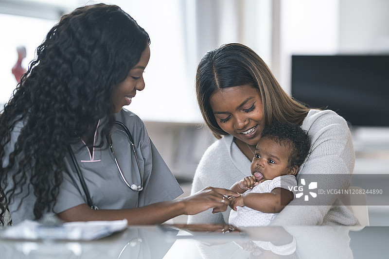 母亲在医疗预约中抱着婴儿图片素材