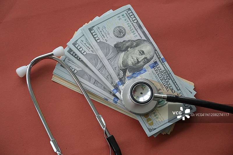 红色背景上的美元大钞和听诊器图片素材