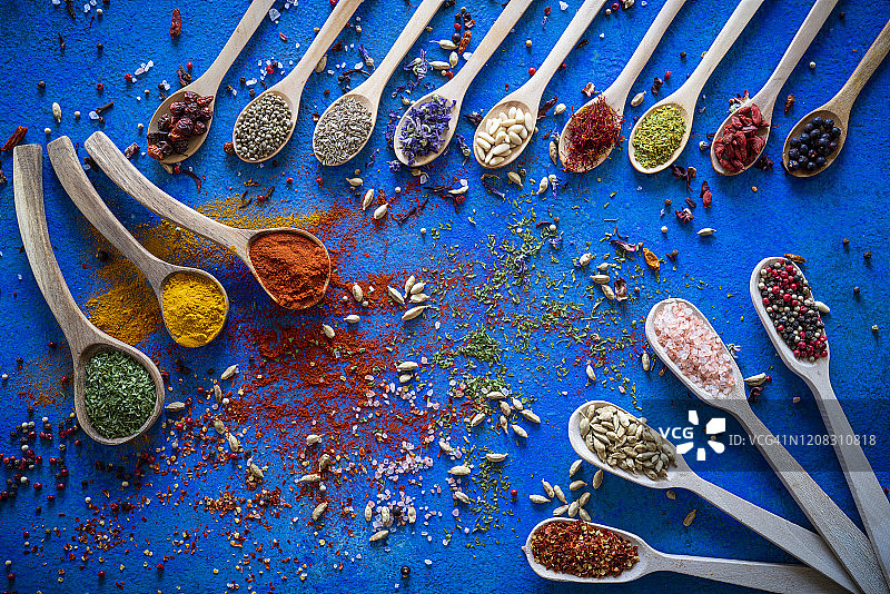 蓝色背景木勺上的香料调味品图片素材