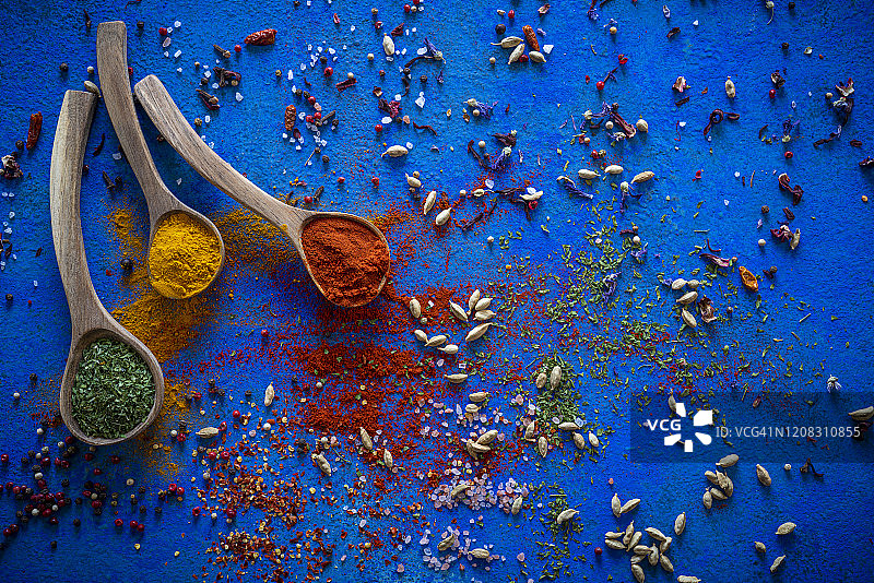 蓝色背景木勺上的香料调味品图片素材