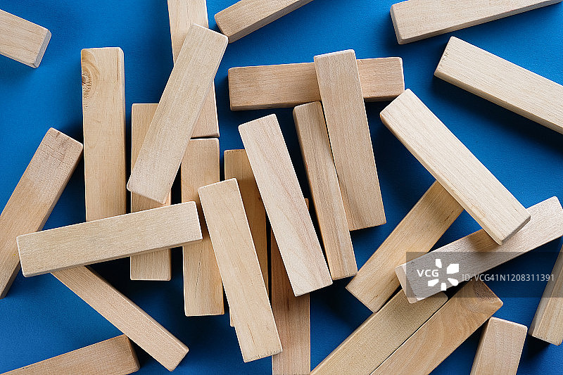蓝色背景上散落的一堆木块：建筑游戏，倒塌的塔图片素材
