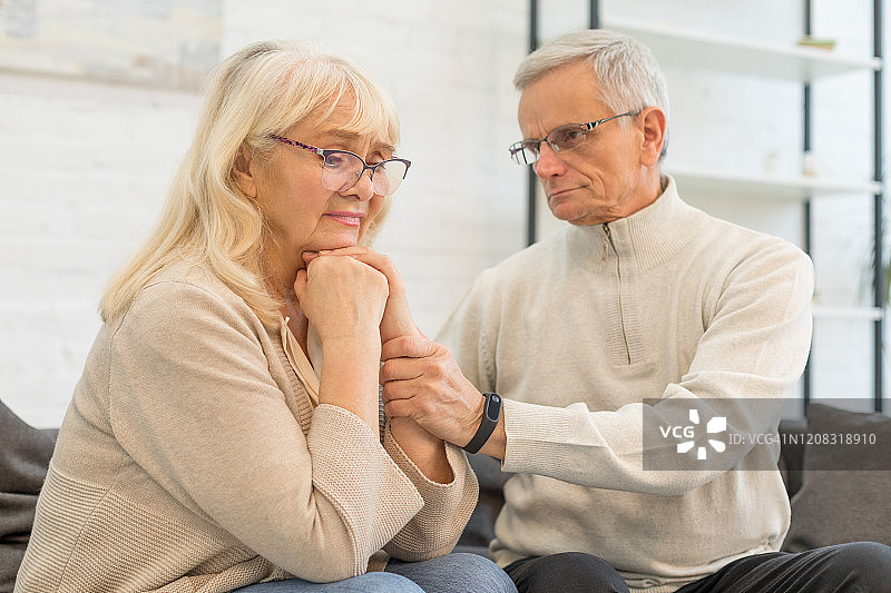 年长的男人看着客厅里沮丧的女人图片素材