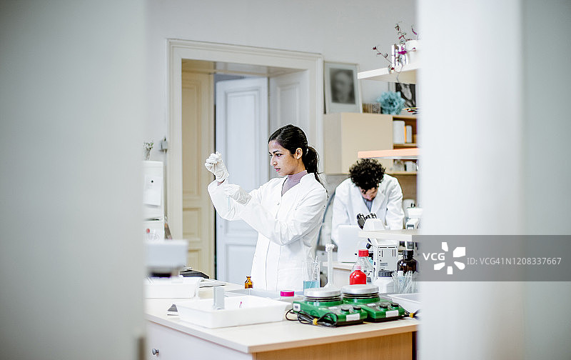 科研人员用移液管向试管中滴入液体图片素材