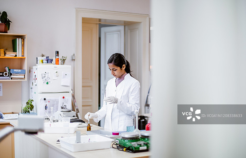 科研人员用移液管向试管中滴入液体图片素材