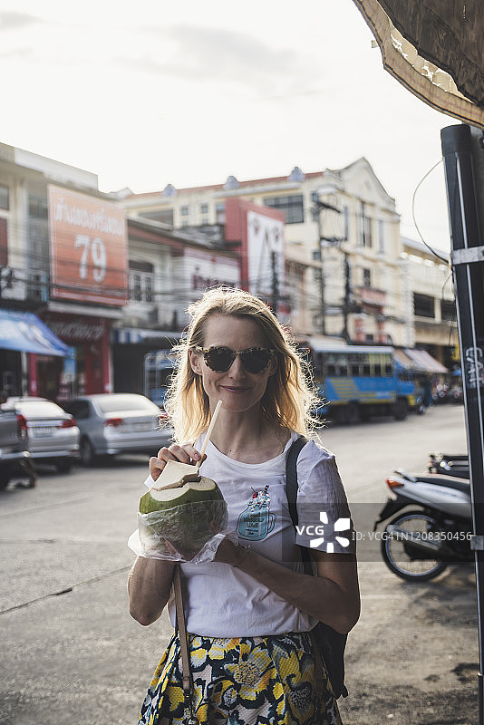 在泰国普吉老镇喝椰汁的微笑女性 портрет图片素材