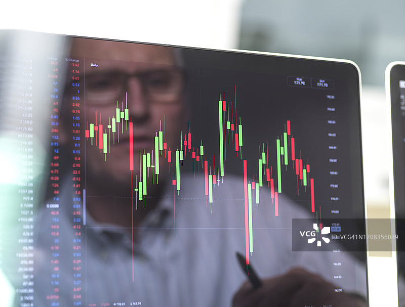 商人观看公司股价屏幕的倒影图片素材