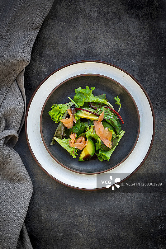 拌有玉米沙拉、芝麻菜、菠菜、红叶生菜、甜菜叶、鳄梨、三文鱼肉和香醋的蔬菜沙拉拼盘图片素材