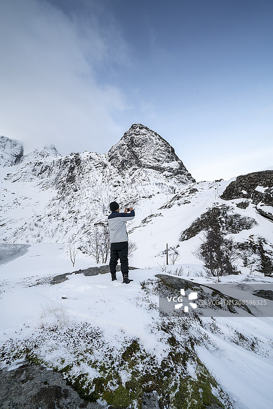 在雪山徒步的亚洲男人图片素材