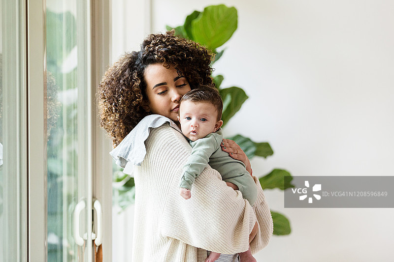 年轻妈妈在家照顾宝宝图片素材