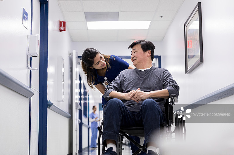 细心护士与坐轮椅的病人交谈图片素材