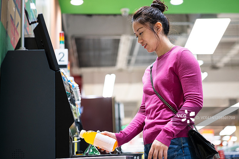 女人在超市用自助付款机结账图片素材