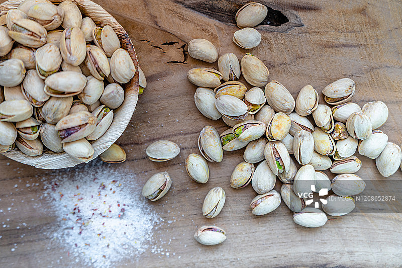 木制背景上的咸味开心果图片素材