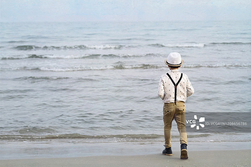 男孩在海滩上奔跑向大海图片素材