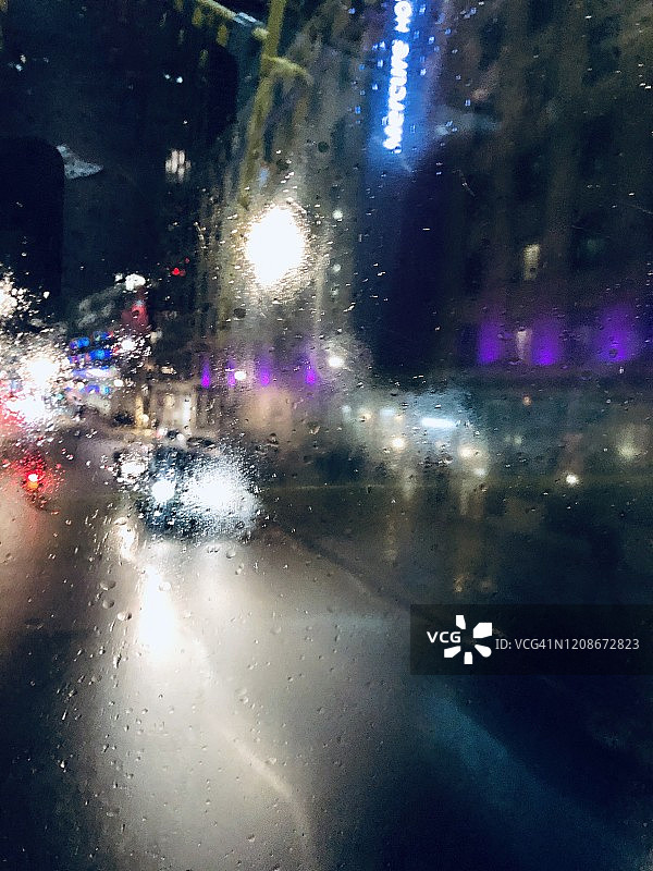 伦敦街景：巴士顶视角的冬季暴雨夜景，光线模糊的十字路口图片素材