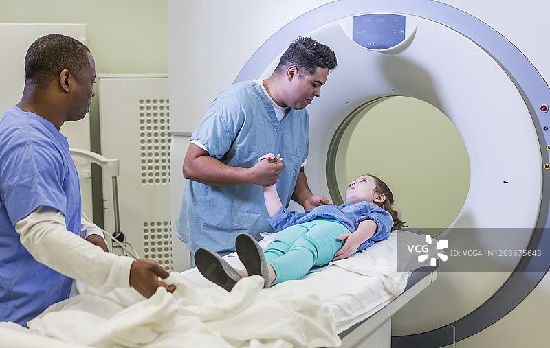 技术员与接受CT扫描的女孩交谈图片素材