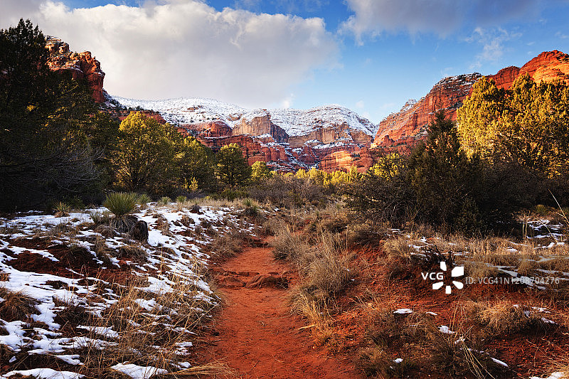 覆盖在悬崖上的新雪，悬崖耸立在通往亚利桑那州塞多纳费伊峡谷的小路上图片素材