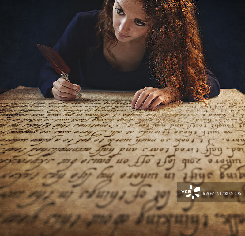 年轻女人用羽毛笔书写，影棚拍摄图片素材