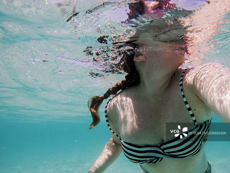 清澈水域女子游泳水下视角图片素材