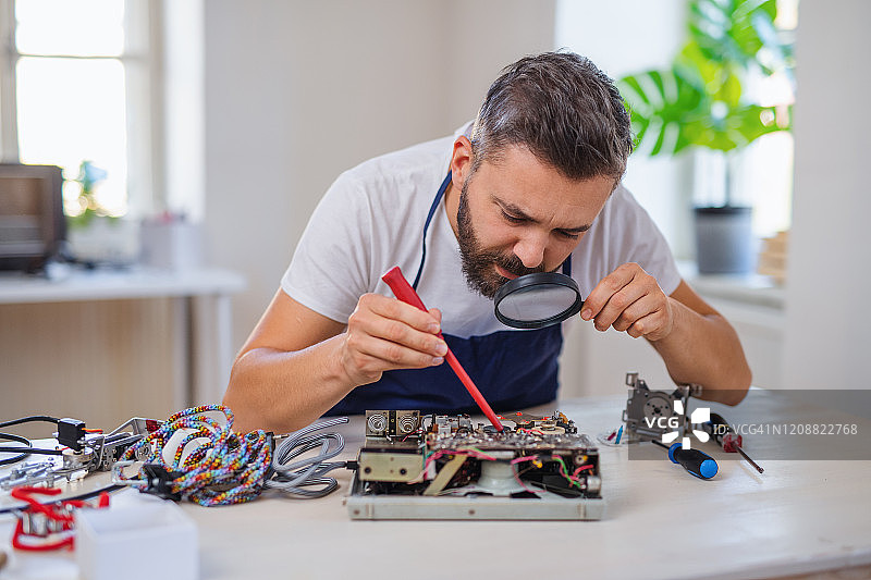 中年男人在社区中心修理家用设备图片素材