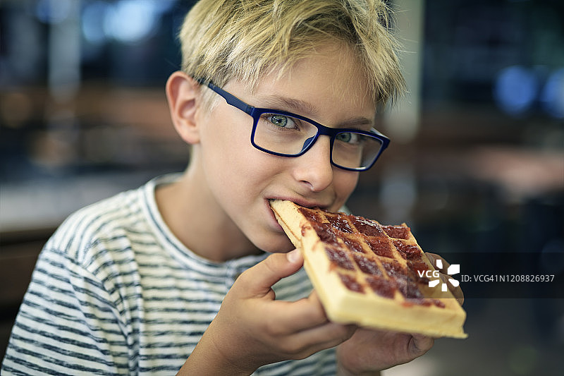 小男孩吃草莓酱华夫饼图片素材