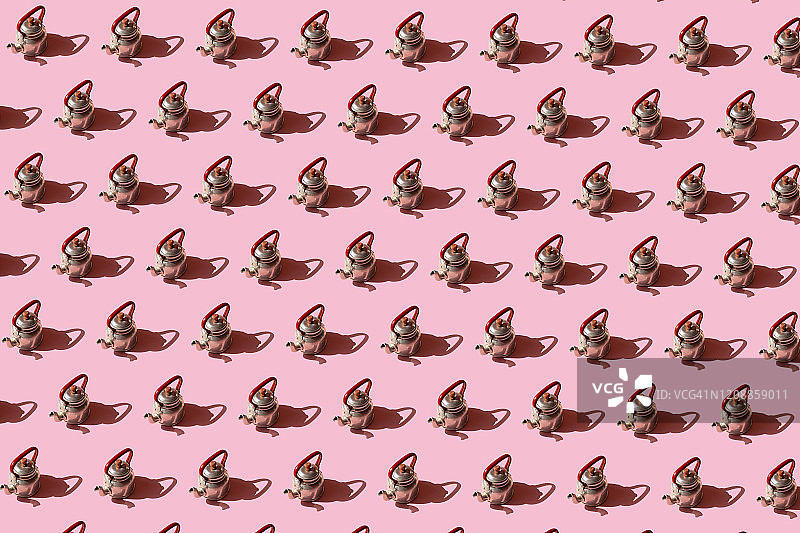 粉色背景上重复的旧铝制茶壶图片素材