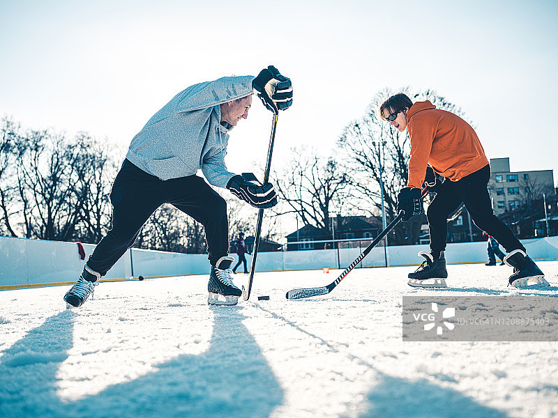 父子在户外打冰球图片素材