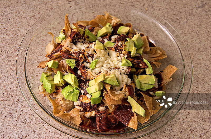 自制奇拉基莱斯配玉米片、鸡丝、奶酪、辣椒酱和牛油果图片素材