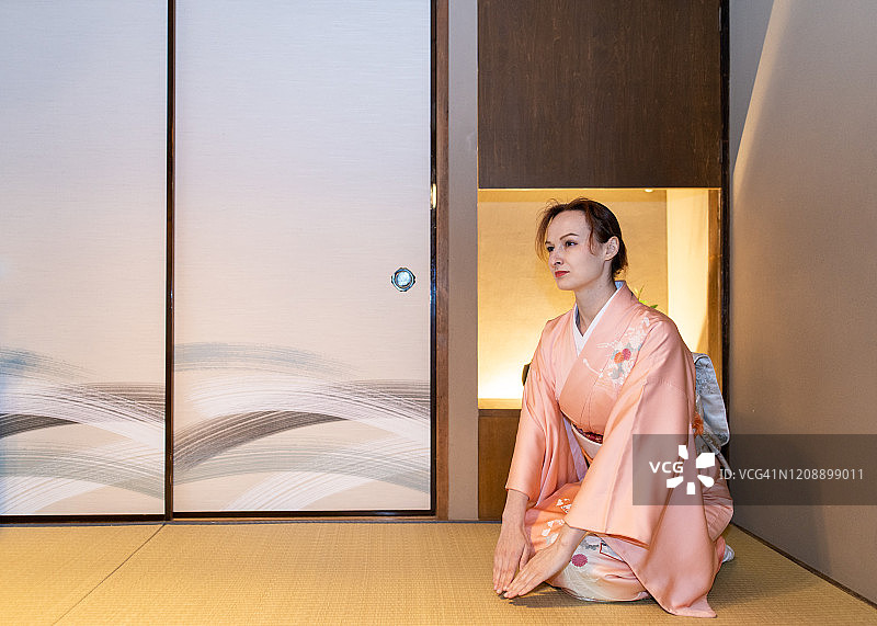 穿着和服的俄罗斯旅馆老板在榻榻米房间里问候图片素材