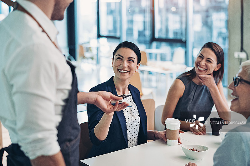 在咖啡馆用信用卡支付的女商人图片素材