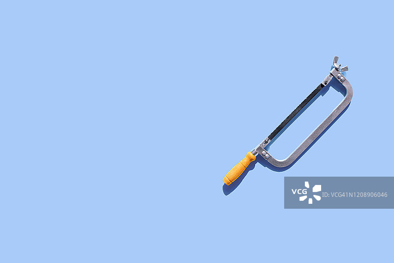 蓝色背景上的旧钢丝锯图片素材