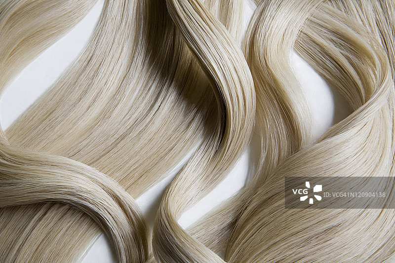 白色背景上的金色波浪发静物图片素材